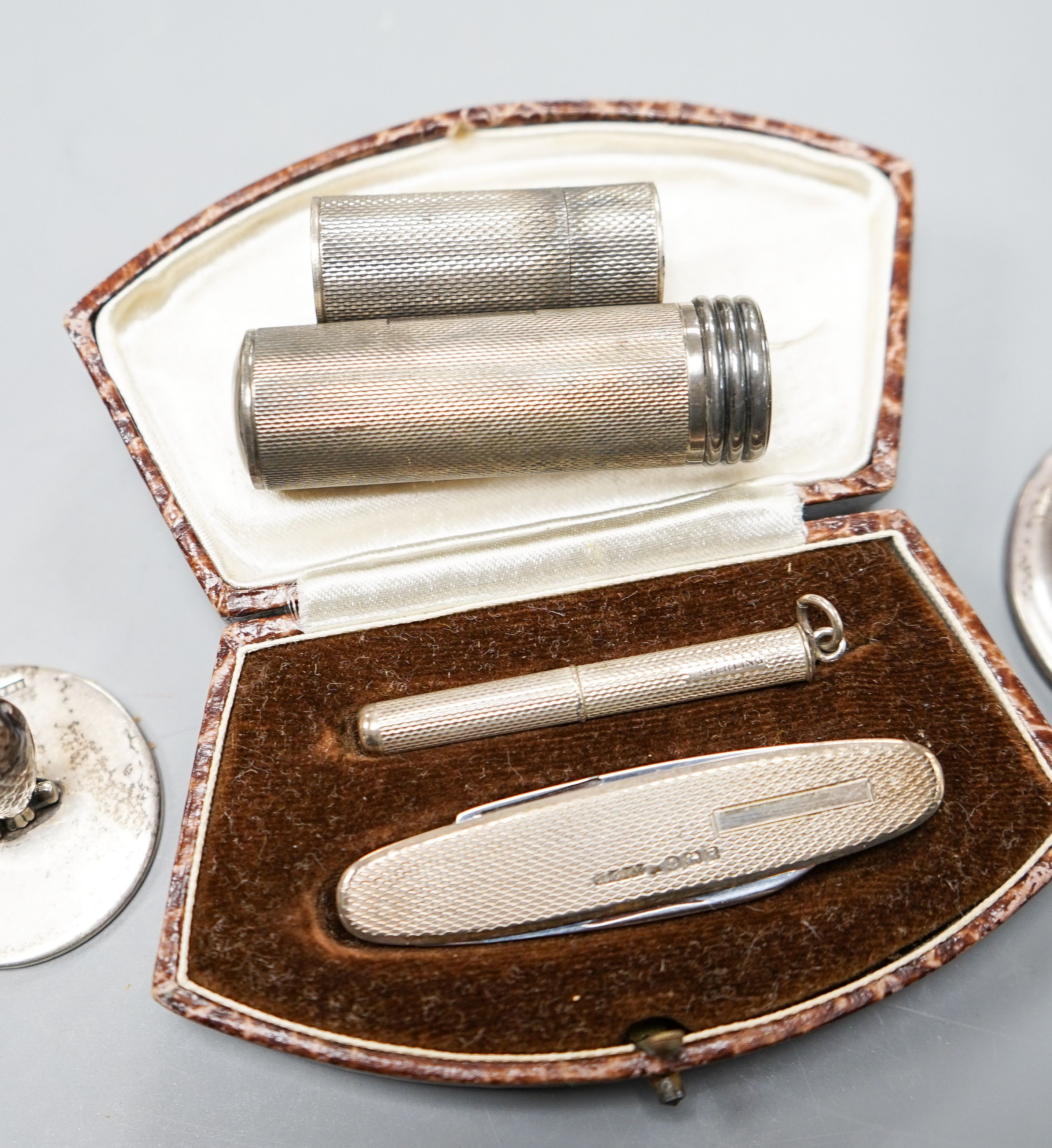 Three silver 'owl' menu holders, including a pair by Samson Mordan & Co, London, 1926, 30mm an engine-turned silver penknife and toothpick set (cased) and two silver cylindrical containers.